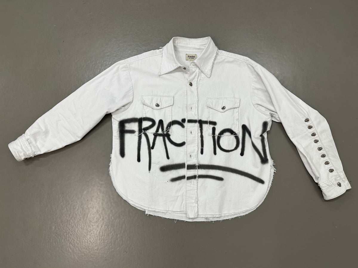 White double-layer FRACTION button-down with black spray-painted lettering and skull buttons