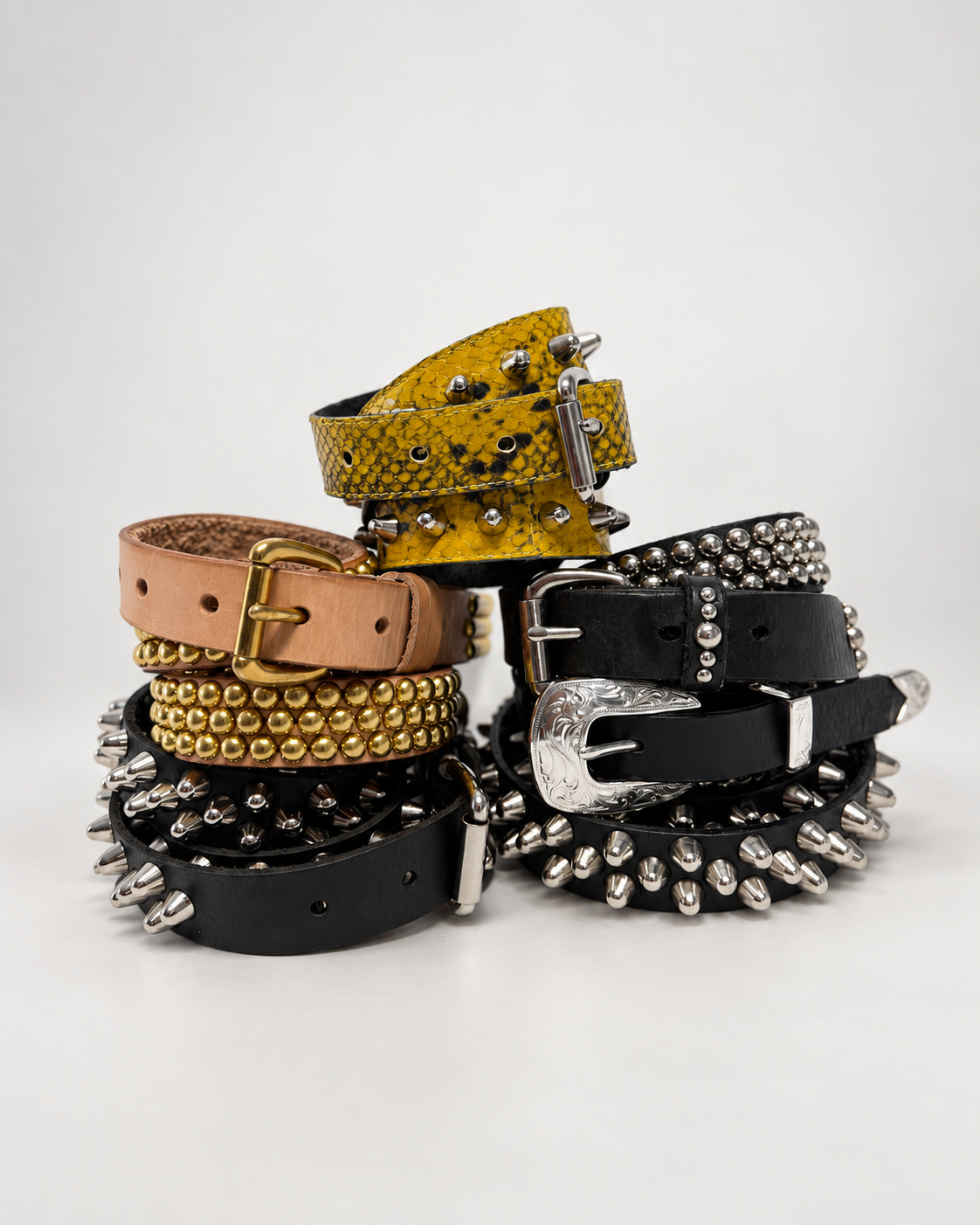 Five Fraction studded leather belts stacked in the studio